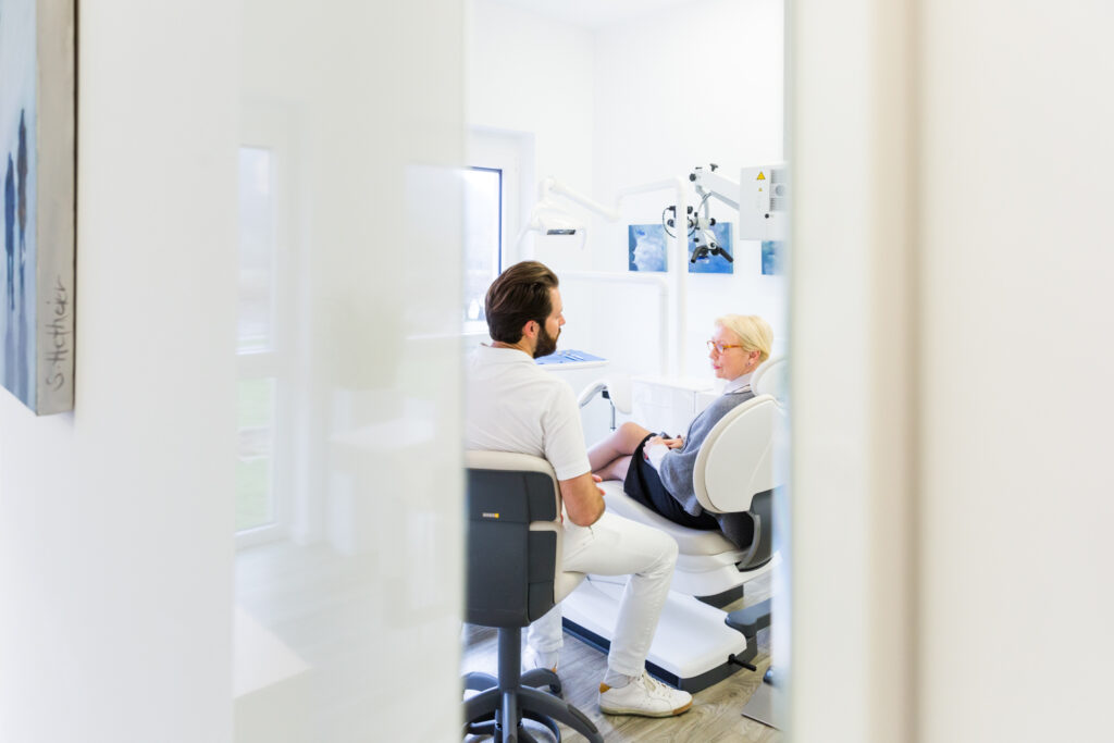 Herr Dr. Marc Hetheier führt eine Kontrolluntersuchung (Prophylaxe) bei einer Patientin durch.